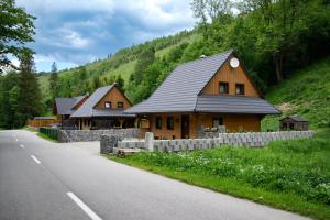 a wooden house on the side of a road at Chata Snezienka in Oščadnica