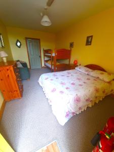 um quarto com uma cama e uma parede amarela em Slane Farm Hostel, Cottages and Camping em Slane