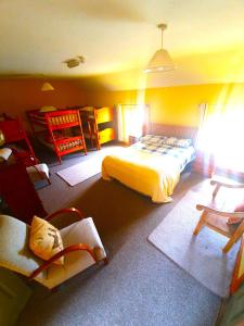 a bedroom with a bed and two chairs in it at Slane Farm Hostel, Cottages and Camping in Slane