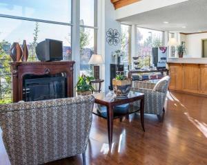 een woonkamer met een open haard en een tafel en stoelen bij Quality Inn & Suites Cameron Park Shingle Springs in Cameron Park