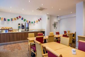 un restaurante con mesas, sillas y una barra en Comfort Inn Edgware Road en Londres