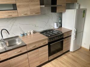 a kitchen with a sink and a stove and a refrigerator at Apartament Karolewo in Karolewo