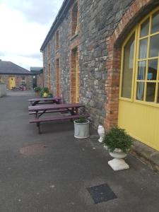 two picnic tables sitting outside of a brick building at Slane Farm Hostel, Cottages and Camping in Slane
