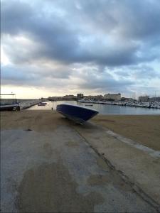 a blue boat sitting on a beach near the water at Virginia in Siracusa