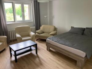 sypialnia z łóżkiem, 2 krzesłami i stołem w obiekcie Apartament Karolewo w mieście Karolewo