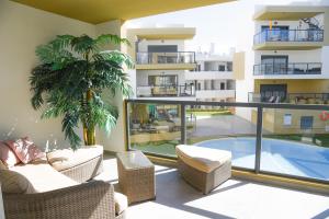 einen Balkon mit Blick auf ein Gebäude mit Pool in der Unterkunft Family apartments Albur Village II in Alvor