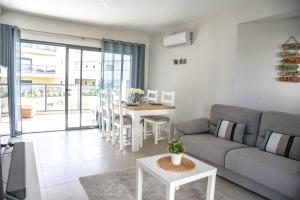 ein Wohnzimmer mit einem Sofa und einem Tisch in der Unterkunft Family apartments Albur Village II in Alvor