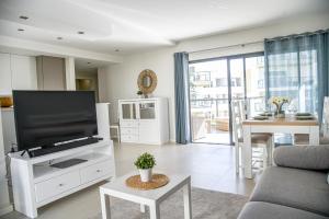a living room with a large flat screen tv at Family apartments Albur Village II in Alvor