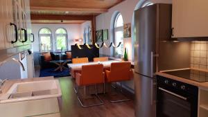 een keuken en eetkamer met een tafel met oranje stoelen bij Wunderschöne Wohnungen im Zentrum von Herzogenaurach in Herzogenaurach