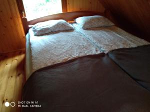 2 łóżka w sypialni z oknem w obiekcie Domek letniskowy-Powidz ul.Topolowa w Powidzu