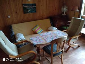salon z kanapą, stołem i krzesłami w obiekcie Domek letniskowy-Powidz ul.Topolowa w Powidzu