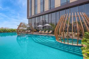 une piscine en face d'un bâtiment dans l'établissement Radisson Blu Hotel & Spa, Nashik, à Nashik