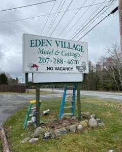 a sign for an eden village motel and car dealership at Eden Village Motel and Cottages in Bar Harbor