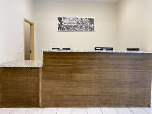a lobby with a wooden counter with three chairs at Sleep Inn - Coliseum Area in Greensboro