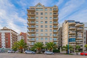 a tall building with cars parked in front of it at Departamento Varese Güemes Alta Gama Luxury 4/5 Pax Vista Mar in Mar del Plata