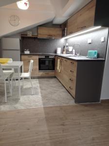 a kitchen with a table and a dining room at Къща за гости-Ганеви in Zmeitsa