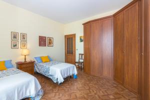 sypialnia z 2 łóżkami i drewnianą szafką w obiekcie Frejus Classic Apartment by Wonderful Italy w Turynie