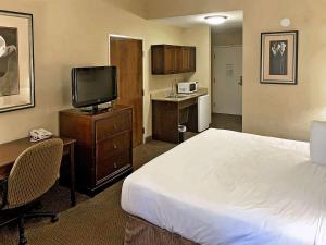 A bed or beds in a room at Rodeway Inn & Suites