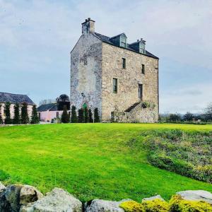 un antiguo edificio de piedra en un campo con césped verde en Buittle Castle Exclusive Use- Stay in your own Castle! en Castle Douglas