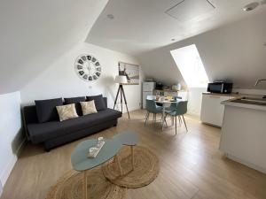 a living room with a couch and a table at Les petits galets - T2 - WIFI - Coeur de ville - Parking in Pont-lʼAbbé