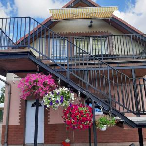 a house with flowers hanging from the stairs at Apartament nad wodą in Marzęcino
