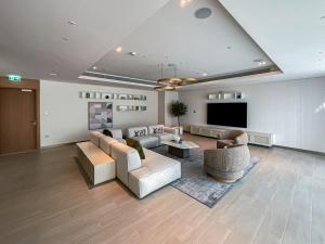 a living room with couches and a flat screen tv at HiGuests - Superlative apt with private beach access in Dubai