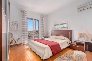 a bedroom with a large bed with a red blanket at Selûne Boutique Home in Skiathos