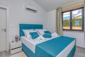 sypialnia z niebiesko-białym łóżkiem i oknem w obiekcie Villa Istria Vabriga w mieście Vabriga +37 zdjęć