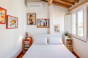 a bedroom with a bed and some pictures on the wall at Piazza dei Cavalieri Orange Attic Apartment in Pisa