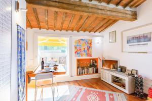 - un salon avec une table et une fenêtre dans l'établissement Piazza dei Cavalieri Orange Attic Apartment, à Pise