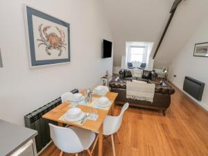 a living room with a table and a couch at Foxton Penthouse in Whitby