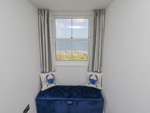 a blue couch in a room with a window at Foxton Penthouse in Whitby