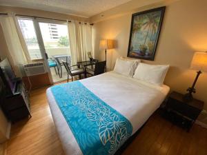 a bedroom with a large bed and a living room at Kuhio Village Towers 2 410a in Honolulu