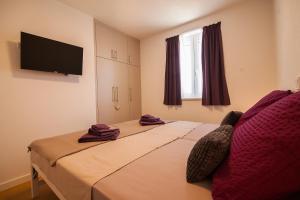 a bedroom with two beds and a flat screen tv at Apartment CasArosa in Bol