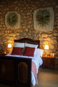 a bedroom with a bed in a stone wall at Casa Rural Hípica Molí categoria superior in Rosell