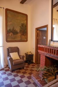 a living room with a chair and a fireplace at Casa Rural Hípica Molí categoria superior in Rosell