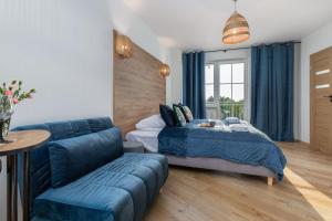 sypialnia z niebieskim łóżkiem i kanapą w obiekcie Zielona Apartment Grzybowo by Renters w Grzybowie