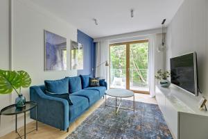 un soggiorno con divano blu e tavolo di Comfort Apartments Dolny Sopot a Sopot