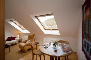 a living room with a table and chairs and a skylight at Gästehaus Heintz in Merzig