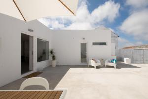 una casa blanca con muebles blancos en un patio en CASASUPERTUBOS - Villa Privada a 10min da Praia, en Atouguia da Baleia
