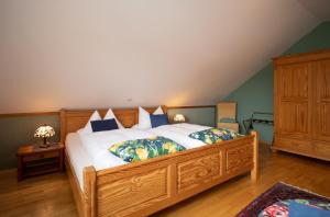 een slaapkamer met een groot houten bed met kussens bij Gästehaus Heintz in Merzig