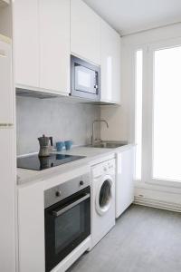 a white kitchen with a sink and a washing machine at Apartamento Pamplona 1 in Pamplona