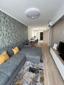 a living room with a gray couch and a television at Lakeside Home in Siófok