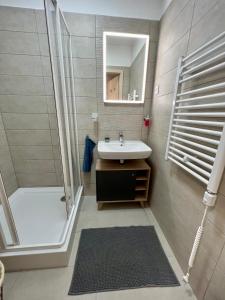 a bathroom with a sink and a shower and a mirror at Lakeside Home in Siófok