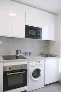 eine Küche mit einer Waschmaschine und einer Mikrowelle in der Unterkunft Apartamento Pamplona 1 in Pamplona