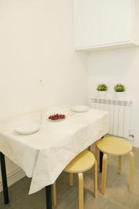 einem weißen Tisch mit zwei Stühlen und einem Teller darauf in der Unterkunft Apartamento Pamplona 1 in Pamplona