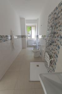 Baño blanco con lavabo y aseo en Villa Maria Cristina d'Amico en Cava deʼ Tirreni