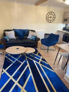 sala de estar con sofá, mesa y sillas en Cackle hill lakes, Kingfisher Lodge, en Biddenden