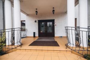 a front door of a house with a rug at Dworek Magnat in Modlniczka