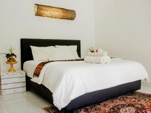 sypialnia z dużym łóżkiem z białą pościelą w obiekcie The Winaposa w mieście Munduk